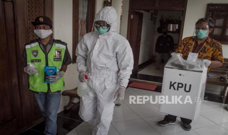 Seorang petugas KPPS mengenakan pakaian hazmat dan Alat Pelindung Diri (APD) menuju ke rumah warga yang menjalani isolasi mandiri saat Simulasi Pilkada di masa pandemi Covid 19.