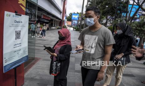 Pengunjung antre untuk memindai kode batang pada aplikasi Peduli Lindungi sebelum memasuki Bandung Indah Plaza (BIP), Jalan Merdeka, Kota Bandung, Jumat (8/7/2022). Pemerintah Kota Bandung melalui Perwal No.88 Tahun 2022 mengubah aturan kegiatan di mal dan pusat perbelanjaan di masa PPKM Level 1, yakni mewajibkan pengunjung di atas 18 tahun sudah vaksin dosis ketiga (booster) dan wajib menggunakan aplikasi Peduli Lindungi. Foto: Republika/Abdan Syakura