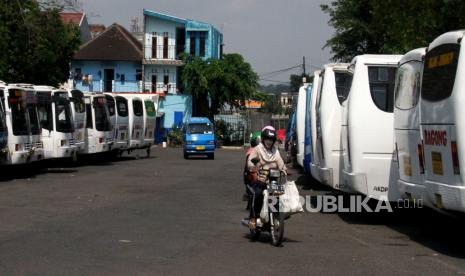 Seorang pengendara motor melintas di depan puluhan bus antar kota yang terparkir dan tidak beroperasi di Terminal Landungsari, Malang, Jawa Timur. Pengusaha armada bus setempat memilih untuk tidak beroperasi dan meliburkan seluruh awak armada meski Kementerian Perhubungan memberi kelonggaran aktivitas transportasi di tengah pandemi COVID-19