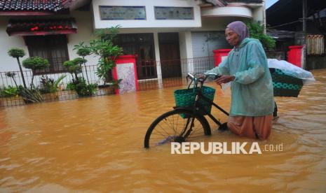 Warga melintasi jalan yang tergenang banjir di Desa Mejobo, Kudus, Jawa Tengah, Kamis (30/1/2025). Banjir akibat intensitas hujan tinggi sejak Selasa (28/1) tersebut menyebabkan meluapnya air Sungai Piji dan Sungai Dawe sehingga sekitar 300 rumah, jalan utama dan beberapa sekolahan di Kecamatan Mejobo terendam hingga ketinggian 30 centimeter. 