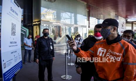 Pengunjung memindai barcode melalui aplikasi PeduliLindungi sebelum memasuki Trans Studio Mall, Jalan Gatot Subroto, Kota Bandung, Rabu (11/8). Pemerintah Kota Bandung kembali membuka 23 mal dan pusat perbelanjaan di masa perpanjangan PPKM Level 4 dengan kapasitas pengunjung sebanyak 25 persen serta menunjukkan sertifikat vaksinasi Covid-19 dan menerapkan protokol kesehatan yang ketat. Foto: Republika/Abdan Syakura