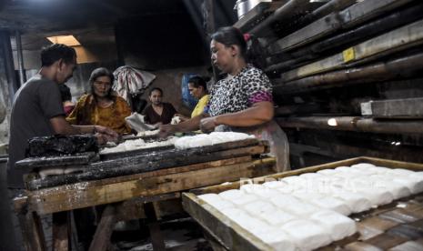 Perajin memproduksi tahu di salah satu industri tahu rumahan di Gang Ibu Anah, Babakan Ciparay, Kota Bandung, Rabu (28/9/2022). Perajin industri tahu rumahan di kawasan tersebut menyatakan dampak dari kenaikan harga kedelai dari sebelumnya Rp10.500 ribu per kilogram menjadi Rp12.800 ribu per kilogram, membuat mereka terpaksa mengurangi jumlah produksi hingga 50 persen atau 10.000 potong tahu menjadi 5.000 potong tahu. Republika/Abdan Syakura