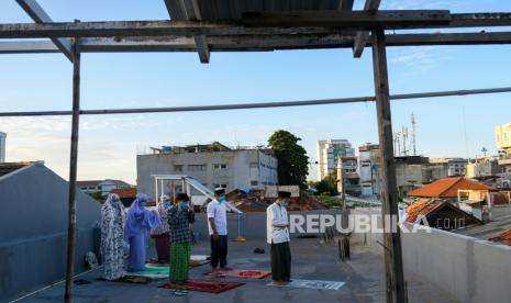 Umat Islam melaksanakan shalat Idul Fitri 1441 Hijriah di lantai atas indekos kawasan Pasar Baru, Jakarta Pusat, Minggu (24/5/2020). Shalat Idul Fitri 1441 Hijriah berjemaah yang dilakukan di rumah dengan jumlah yang terbatas tersebut sesuai imbauan pemerintah guna mencegah penyebaran COVID-19 dan memaksimalkan penerapan Pembatasan Sosial Berskala Besar (PSBB)