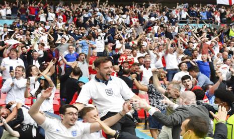 Suporter Inggris merayakan kemenangan saat pertandingan babak 16 besar Piala Eropa 2020 antara Inggris dan Jerman di stadion Wembley, London, Selasa (29/6). Inggris berhasil mengalahkan Jerman pada pertandingan tersebut dengan skor akhir 2-0, melalui gol yang dicetak oleh Raheem Sterling dan Harry Kane. (Justin Tallis, Pool Photo via AP)Putra M. Akbar