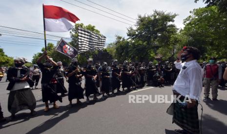 Pengunjuk rasa dari Forum Komunikasi Taksu Bali menyanyikan lagu Indonesia Raya dalam aksi mengecam pernyataan anggota Dewan Perwakilan Daerah (DPD) RI Provinsi Bali I Gusti Ngurah Arya Wedakarna (AWK),  di Kantor DPD RI Provinsi Bali, Denpasar, Bali, Selasa (3/11/2020). Aksi tersebut untuk menyatakan mosi tidak percaya kepada anggota DPD RI komite 1 bidang Pemerintahan, Politik, Hukum, HAM, Pemukiman dan Pertanahan itu karena dinilai menghina serta menodai simbol agama Hindu di Bali. 