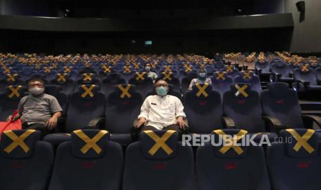 Penonton duduk terpisah di tengah penanda jarak fisik saat menunggu dimulainya film di bioskop CGV Cinemas di Jakarta, Indonesia, Jumat, 23 Oktober 2020. Bioskop CGV buka dengan kapasitas penonton 50 persen mulai Rabu (4/11) di empat lokasi.