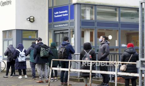  Orang-orang berbaris di luar pusat vaksinasi di NHS Scotland Leith Community Treatment Centre, di Edinburgh, Skotlandia, Senin, 20 Desember 2021. Menteri Kesehatan Inggris telah menolak untuk mengesampingkan penerapan pembatasan COVID-19 yang lebih ketat sebelum Natal di tengah peningkatan pesat infeksi dan ketidakpastian berkelanjutan tentang varian omicron.