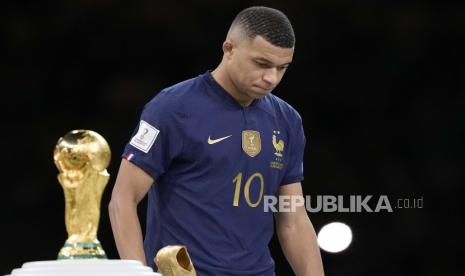 Kylian Mbappe dari Prancis berjalan melewati trofi pada akhir pertandingan sepak bola final Piala Dunia antara Argentina dan Prancis di Stadion Lusail di Lusail, Qatar, Ahad, 18 Desember 2022. Argentina menang 4-2 dalam adu penalti setelah pertandingan berakhir imbang 3-3.