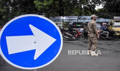 Pemkot Bandung Segel Empat Toko Modern Langgar PSBB. Petugas Satpol PP mengatur arus lalu lintas saat penutupan ruas jalan di Jalan Dipatiukur, Kota Bandung, Ahad (6/12). Dalam pelaksanaan Pembatasan Sosial Berskala Besar (PSBB) Proporsional, Pemerintah Kota Bandung menutup jalan kawasan Dipatiukur selama 14 hari ke depan sebagai upaya mencegah potensi kerumunan warga dan wisatawan guna meminimalisir penyebaran Covid-19 di Kota Bandung. Foto: Abdan Syakura/Republika