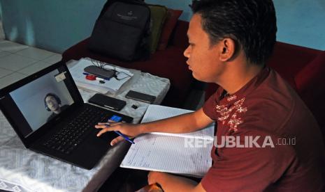 Pelajar menyimak paparan guru saat proses belajar mengajar secara daring di rumahnya. Ilustrasi