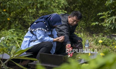 Warga menabur bunga di makam keluarganya saat berziarah di Tempat Pemakaman Umum (TPU) Cikadut, Mandalajati, Kota Bandung, Jawa Barat, Senin (20/3/2023). Menjelang bulan suci Ramadhan, TPU Covid-19 Cikadut ramai dikunjungi peziarah yang datang untuk mendoakan keluarga serta kerabat yang telah wafat.