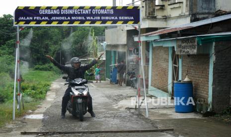 Warga membasuh diri di gerbang disinfektan yang terpasang di pintu masuk kampung Kalipakis, Kasihan, Bantul, Daerah Istimewa Yogyakarta (DIY), Senin (23/3/2020). Gerbang yang dilengkapi sensor gerak otomatis untuk mengeluarkan kabut disinfektan karya warga setempat itu menjadi salah satu upaya pencegahan terhadap penyebaran virus corona (COVID-19)