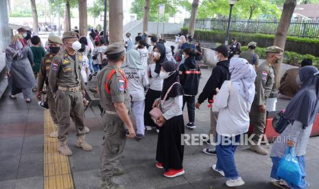 Petugas Satpol PP Kota Bandung, mengingatkan pengunjung agar tetap mengenakan masker dan menjaga prokes di kawasan Alun-alun Kota Bandung, Kamis (10/2/2022). Kota Bandung saat ini kembali masuk PPKM level 3 di tengah lonjakan Covid-19 varian omicron. Semua unsur satgas Covid-19 kembali gencar mengingatkan warga untuk selalu mematuhi prokes dan aturan yang berlaku.