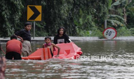 Sejumlah bocah bermain di ruas jalan yang terendam banjir (ilustrasi).