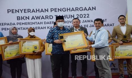 Wakil Kepala BKN, Supranawa Yusuf memberikan penghargaan BKN Award Tahun 2022 dari Badan Kepegawaian Negara (BKN) kepada Gubernur Jawa Barat Ridwan Kamil dan sejumlah kepala daearah kabupaten/kota di Jawa Barat, di Aula Barat, Gedung Sate, Kota Bandung, Selasa (23/8). Penghargaan BKN diberikan kepada instansi pemerintah yang telah berhasil melaksanakan penyelenggaraan manajemen ASN, mulai dari aspek pengadaan, manajemen kinerja, penerapan Norma Standar Prosedur dan Kriteria (NSPK), sampai dengan pemanfaatan layanan digital ASN.