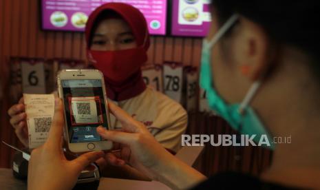 Pengunjung melakukan transaksi pembayaran non tunai dengan menggunakan Scan QRIS (ilustrasi)