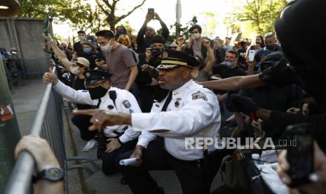 Deputi Komisaris Polisi Philadelphia Melvin Singleton (tengah) berlutut dan meminta polisi lain untuk bergabung dengannya saat aksi menyerukan keadilan atas kematian George Floyd di luar markas besar Kepolisian Philadelphia, Senin (1/6). Floyd meninggal setelah ditahan oleh Minneapolis petugas polisi pada 25 Mei