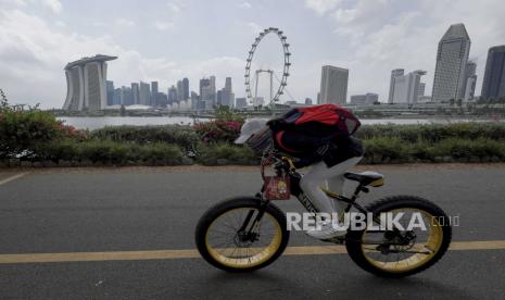 Seorang pengendara sepeda bersepeda melewati cakrawala distrik keuangan melintasi Gardens by the Bay East di Singapura, 15 Februari 2021. Singapura membuka diri bagi semakin banyak negara terkait perjalanan bebas karantina. Ilustrasi.