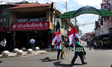 Pedagang kaki lima membawa bendera merah putih untuk dipasang di sepanjang Jalan Malioboro, Yogyakarta. Pemerintah Kota (Pemkot) Yogyakarta membatasi waktu parkir dan kunjungan wisatawan di kawasan Malioboro. Wakil Wali Kota Yogyakarta, Heroe Poerwadi mengatakan, parkir hanya diperbolehkan maksimal tiga jam dan waktu kunjungan wisatawan hanya diperbolehkan selama dua jam.