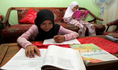 Pelajar mengerjakan tugas sekolah di rumahnya di Makassar, Sulawesi Selatan