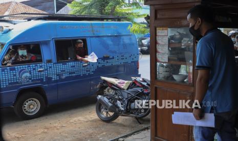 Polisi memberikan sosialisasi kepada warga pemilik warung saat sosialisasi PPKM Darurat. 