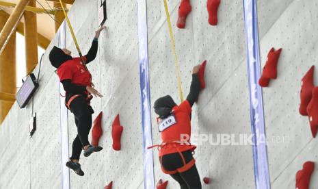 Atlet panjat tebing Jawa Tengah Aries Susanti (kiri) beradu cepat dengan lawannya asal Sulawesi Selatan Alivany Ver Khadijah (kanan) dalam babak kualifikasi nomor speed world record perorangan putri cabang panjat tebing PON Papua di Arena Panjat Tebing SP 2 Kabupaten Mimika, Papua, Selasa (28/9/2021). 