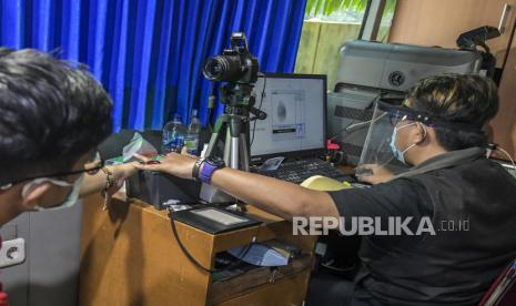 Petugas melayani warga yang memperpanjang surat izin mengemudi (SIM) di layanan SIM keliling di kawasan Kalibata, Jakarta. 