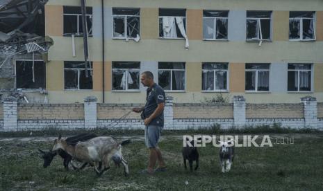 Seorang pria berjalan dengan kambing di sebelah sekolah yang hancur setelah penembakan Rusia di Druzhkivka, wilayah Donetsk, Ukraina, Selasa, 30 Agustus 2022. Kepala Dana Moneter Internasional (IMF) Kristalina Georgieva mengatakan ia dan Presiden Ukraina Volodymyr Zelenskyy sepakat mengeksplorasi cara untuk memperluas dukungan IMF ke negara yang sedang berperang itu. 