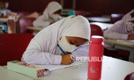 Siswa memakai masker saat belajar di kelas di sebuah sekolah dasar di Depok, Indonesia. Kemenkes mengingatkan masyarakat untuk tetap taat protokol kesehatan demi mencegah penularan Omicron.