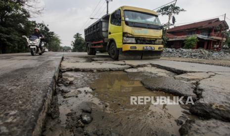 Sejumlah kendaraan menghidari jalan berlubang di Jalan Sudamanik, Parung Panjang, Kabupaten Bogor, Jawa Barat, Senin (20/11/2023). Kondisi jalan yang rusak serta berlubang dan keberadaan truk muatan tambang yang beroperasi pada jam yang belum ditentukan tersebut dapat membahayakan keselamatan pengendara lain.