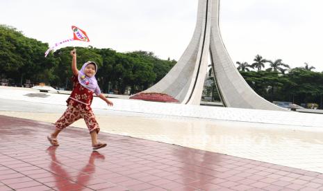 Seorang anak bermain di dekat Tugu Api Pancasila di TMII, Jakarta, Ahad (12/9). Pemprov DKI Jakarta mulai membuka area publik, taman umum dan tempat wisata dengan kapasitas maksimal 25 persen.