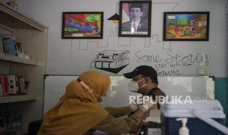 Petugas kesehatan menyuntikkan vaksin COVID-19 di RPTRA Teratai Tebet Timur, Tebet, Jakarta Selatan. Puskesmas Cilandak, Jakarta Selatan, menggencarkan layanan vaksinasi hingga malam.