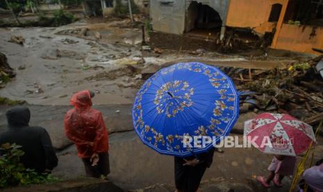 Warga mengamati proses evakuasi akibat banjir bandang di Kampung Cibuntu, Desa Pasawahan, Kecamatan Cicurug, Kabupaten Sukabumi, Jawa Barat, Selasa (22/9). Banjir bandang tersebut terjadi pada Senin (21/9) pukul 17.00 WIB akibat luapan sungai Citarik-Cipeuncit yang merendam tiga kecamatan yakni Cicurug, Parungkuda, Cidahu dan menyebabkan 234 rumah rusak, 210 kepala keluarga mengungsi serta tiga orang meninggal dunia. Republika/Thoudy Badai