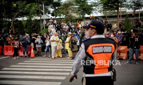 Warga bersiap melakukan peragaan busana Citayam Fashion Week di kawasan Dukuh Atas, Jakarta, Rabu (27/7/2022). Sejumlah petugas gabungan dari Dishub dan Satpol PP melakukan penjagaan dan normalisasi fungsi zebra cross untuk penyeberangan serta perlintasan kendaraan motordan mobil. Meski demikian, kegiatan fashion show jalanan tersebut masih tetap berlangsung dengan imbauan untuk menjaga ketertiban agar tidak terjadi kemacetan. Republika/Thoudy Badai