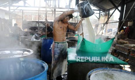  Seorang pria menyaring bubur kedelai rebus panas menggunakan kain lembut sebagai bagian dari proses pembuatan tahu di pabrik tahu tradisional di Banda Aceh, 22 Februari 2022. Industri tahu mengalami kesulitan karena mahalnya harga kedelai di Indonesia . Menurut data yang dirilis Badan Pusat Statistik Indonesia, sepanjang tahun 2021 saja, total impor kedelai mencapai 2,49 juta ton dengan nilai 1,48 miliar dolar AS, dengan Amerika Serikat sebagai importir terbesar dari Indonesia.