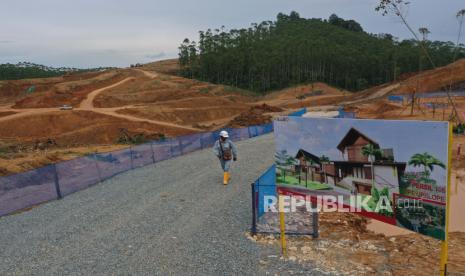 Pekerja melintas di lokasi proyek pembangunan Rumah Tapak Jabatan Menteri di IKN Nusantara, Sepaku, Kabupaten Penajam Paser Utara, Kalimantan Timur, Selasa (28/2/2023). 