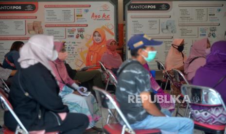 Warga antre saat penyaluran bantuan langsung tunai (BLT) subsidi minyak goreng di Kantor Pos.