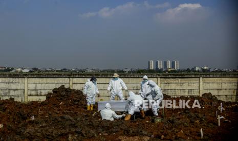 Petugas menggunakan baju hazmat saat memakamkan jenazah pasien Covid-19 (ilustrasi)