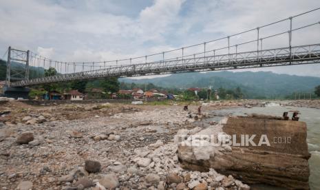 Warga beraktivitas di bawah jembatan gantung yang telah dibangun di Desa Banjar Irigasi, Lebak, Banten, Selasa (15/6/2021). Kementerian Pekerjaan Umum dan Perumahan Rakyat (PUPR) menyelesaikan 12 perbaikan jembatan yang sebelumnya rusak akibat diterjang bencana banjir bandang di Kabupaten Lebak guna mempermudah akses masyarakat. 