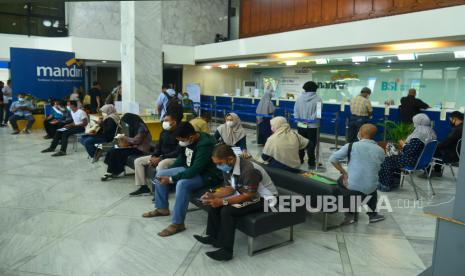 Sejumlah nasabah Bank Mandiri antre untuk melakukan transaksi. Gubernur Bank Indonesia (BI) Perry Warjiyo mengatakan sebanyak 1,7 miliar penduduk dunia belum mempunyai akses pada sektor keuangan. 