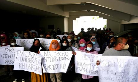 Pedagang kaki lima Malioboro membawa poster saat audensi dengan anggota DPRD Kota Yogyakarta di Gedung DPRD Kota Yogyakarta, Senin (17/1/2022). Pedagang kaki lima Malioboro mengadu ke DPRD Kota Yogyakarta terkait rencana relokasi PKL ke tempat baru yakni di bekas Bioskop Indra dan lahan eks Dinas Pariwisata Yogyakarta pada awal Februari 2022. Pedagang kaki lima meminta penundaan relokasi satu hingga tiga tahun mendatang.