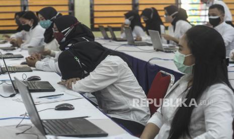 Peserta menunggu dimulainya tes Calon Aparatur Sipil Negara (CASN) di Balai Rakyat, Depok, Jawa Barat, Ahad (3/10)