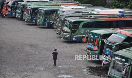 Seorang sopir berjalan di depan jajaran bus antarkota antarprovinsi (AKAP) yang dikandangkan di kawasan Medan Amplas, Sumatera Utara, Minggu (26/4/2020). Sejak adanya pembatasan mobilitas larangan mudik yang dilakukan oleh pemerintah guna mencegah penyebaran COVID-19, sejumlah pengusaha perusahaan otobus AKAP terpaksa mengandangkan armada sementara serta merumahkan supir dan kondektur akibat menurunnya pendapatan