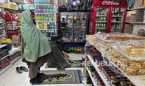 Pejuang Taliban salat magrib di dalam supermarket, di Kabul, Afghanistan, Rabu, 9 Februari 2022. Perserikatan Bangsa-Bangsa (PBB) akan memulai sistem penukaran uang dolar dengan mata uang lokal Afghanistan pada Februari ini. 