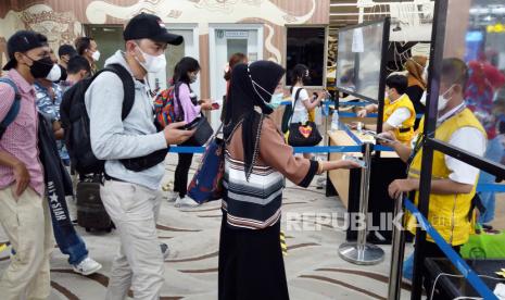 Penumpang pesawat diperiksa oleh petugas kesehatan sesaat setelah tiba di Bandara Internasional Soekarno-Hatta di Tangerang, Indonesia. 