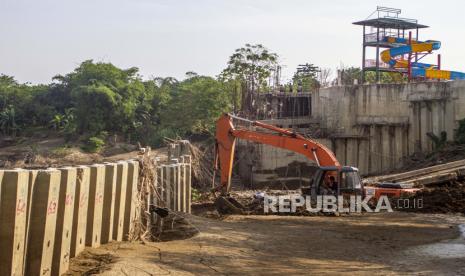 Petugas mengoperasikan alat berat saat membongkar dinding turap (sheet pile) yang terpasang di tengah bantaran sungai Cibeet di Desa Cipayung, Cikarang Timur, Kabuaten Bekasi, Jawa Barat, Kamis (25/6/). Kementerian Agraria dan Tata Ruang / Badan Pertanahan Nasional (ATR/BPN) membongkar dinding turap di tengah sungai Cibeet yang dipasang oleh oknum pengelola objek wisata yang tidak memiliki izin pemanfaatan ruang yang berpotensi merusak sempadan dan kualitas air sungai. 