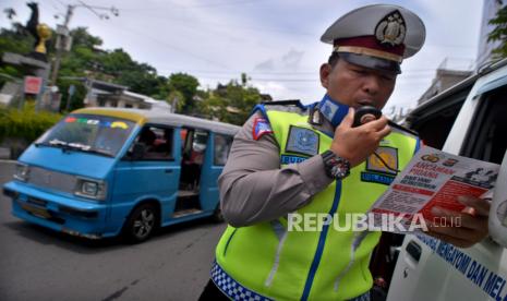 Anggota Satlantas Polres Manado membacakan maklumat Kapolri menggunakan pengeras suara bagi warga yang melintas di ruas jalan di Manado, Sulawesi Utara.  Sebanyak 44 orang dikategorikan Pasien Dalam Pengawasan (PDP) yang dirawat di sejumlah rumah sakit rujukan di Sulawesi Utara (Sulut) meninggal.