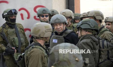 Israeli Prime Minister Benjamin Netanyahu, center, wears a protective vest and helmet as he receives a security briefing with commanders and soldiers in the northern Gaza Strip, on Monday, Dec. 25, 2023. 