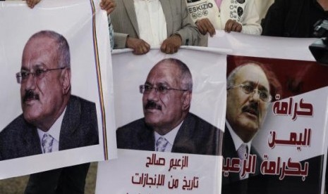 Journalists who support Yemen's former President Ali Abdullah Saleh carry posters bearing his image at the headquarters of his General People's Congress (GPC) party in Sanaa November 6, 2014.