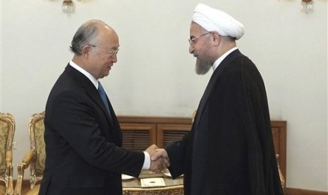 Iran's President Hassan Rouhani (right) shakes hands with Director General of the International Atomic Energy Agency Yukiya Amano at the start of their meeting in Tehran, Iran, Sunday, Aug. 17, 2014. 